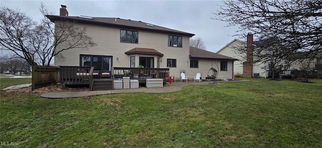 rear view of house featuring a yard, a chimney, a patio area, and a wooden deck