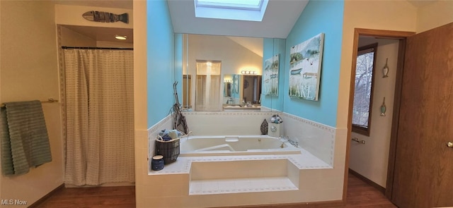 bathroom with vaulted ceiling with skylight, a garden tub, a shower with shower curtain, and wood finished floors