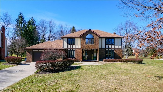 tudor-style house with brick siding, a chimney, concrete driveway, a garage, and a front lawn