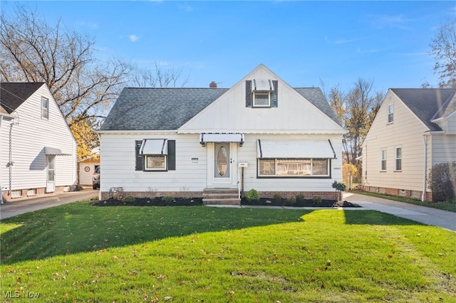 view of front facade with a chimney, roof with shingles, and a front yard