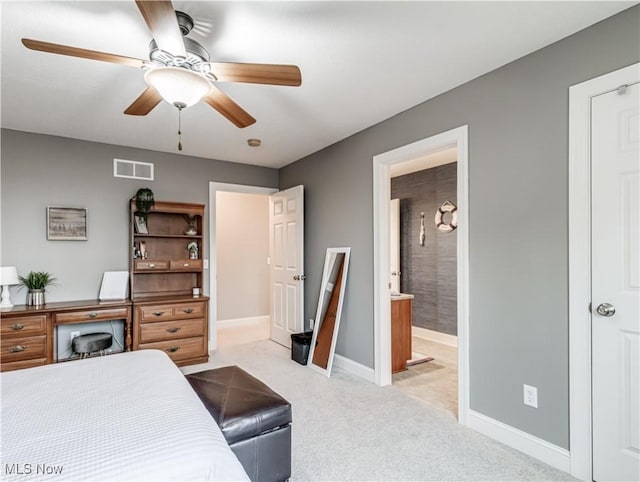 bedroom featuring ceiling fan, ensuite bathroom, light colored carpet, visible vents, and baseboards