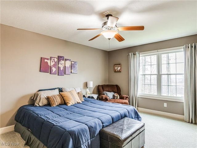 bedroom featuring light carpet, ceiling fan, and baseboards