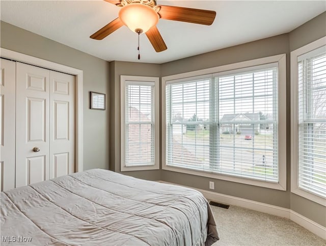 bedroom featuring ceiling fan, carpet flooring, visible vents, baseboards, and a closet