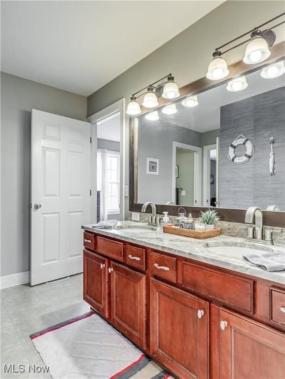 bathroom featuring double vanity, a sink, and baseboards