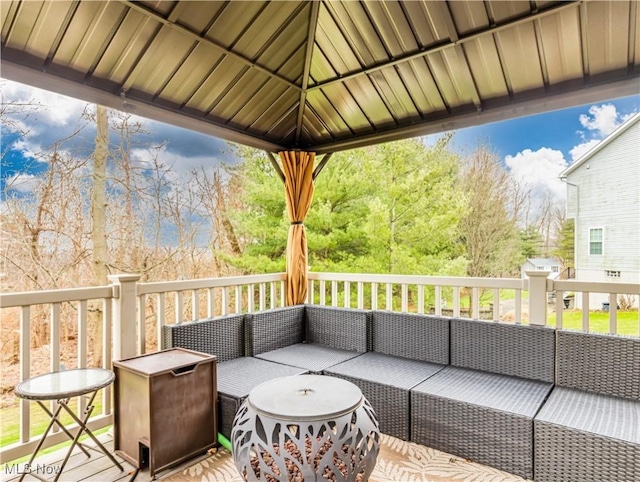 wooden deck featuring an outdoor living space and a gazebo