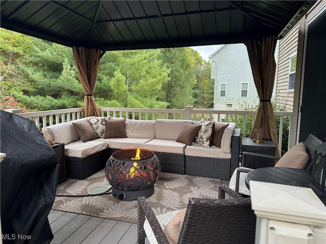 wooden deck featuring a gazebo and an outdoor living space with a fire pit