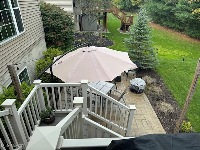 exterior space featuring stairway, a patio area, and a lawn