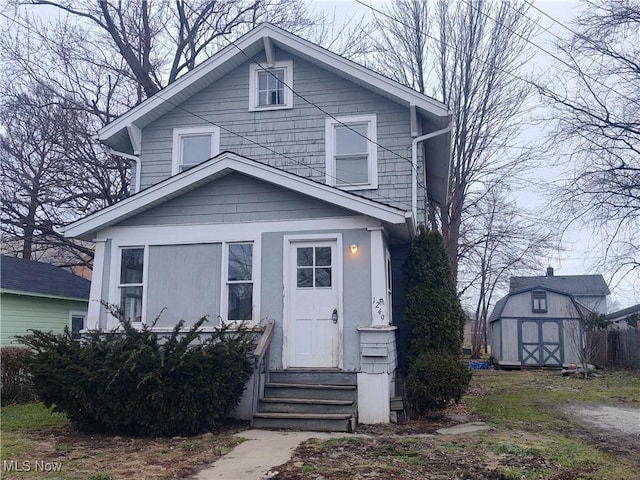 american foursquare style home with entry steps, a shed, and an outbuilding