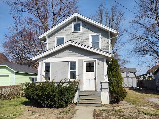 american foursquare style home with entry steps, a storage shed, and an outdoor structure