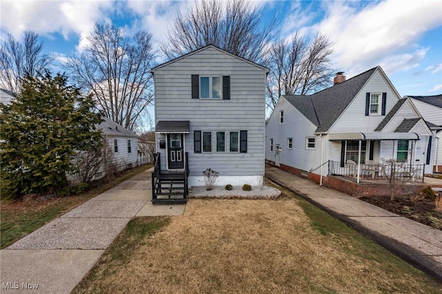 traditional-style home featuring a front lawn and a porch