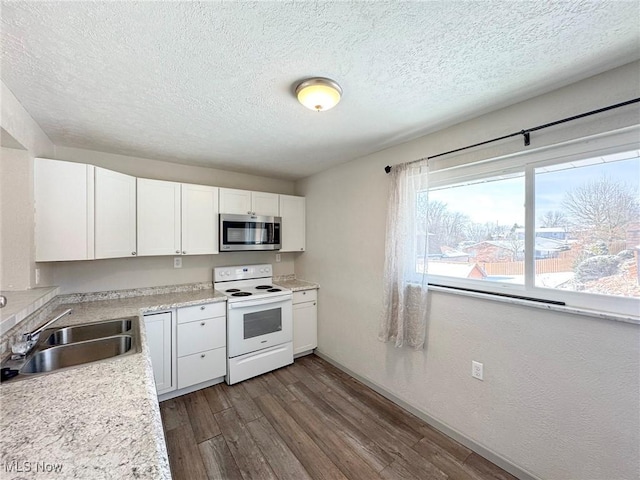 kitchen featuring electric stove, dark wood-style floors, stainless steel microwave, white cabinetry, and a sink