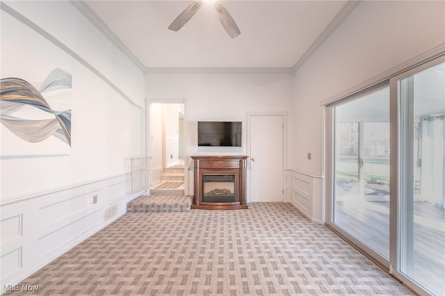 unfurnished living room with light carpet, ornamental molding, and a decorative wall