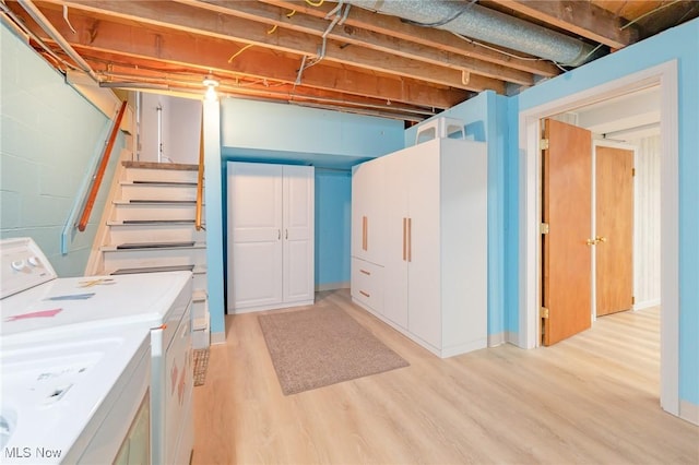 unfinished basement featuring washer / dryer, light wood-style floors, and stairway