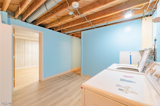 laundry room featuring laundry area, wood finished floors, washing machine and dryer, and baseboards