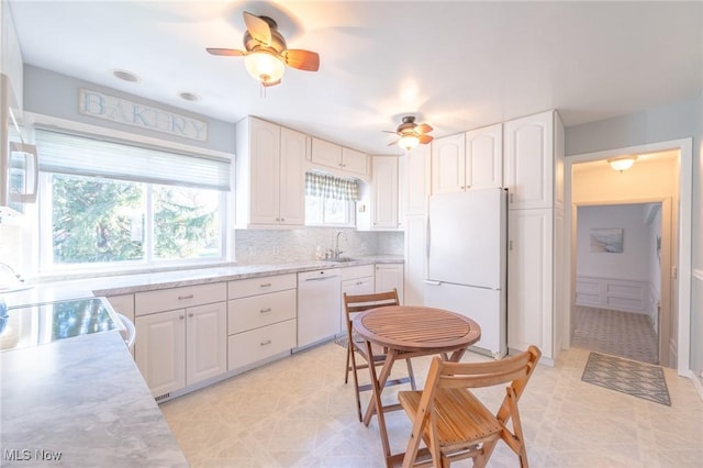 kitchen with light floors, light countertops, decorative backsplash, white cabinets, and white appliances