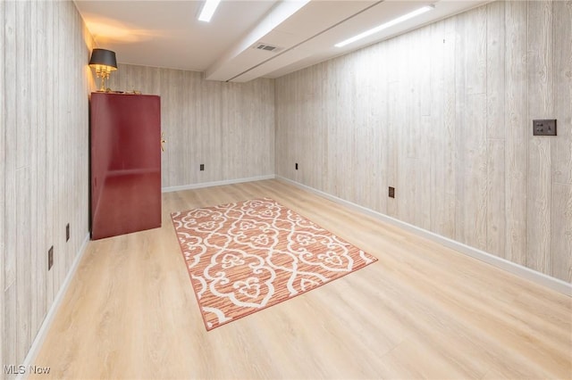 spare room with visible vents, baseboards, and wood finished floors