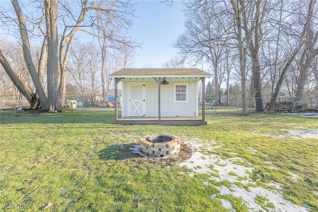 view of shed featuring a fire pit and fence