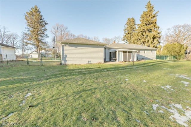 back of house featuring a gate, fence, and a lawn