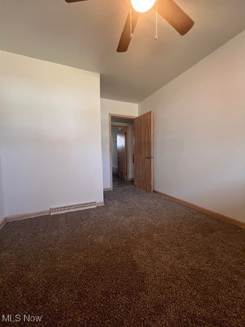 spare room with carpet, baseboards, and ceiling fan