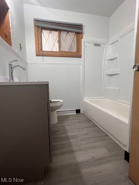 full bathroom with shower / bathing tub combination, vanity, toilet, and wood finished floors