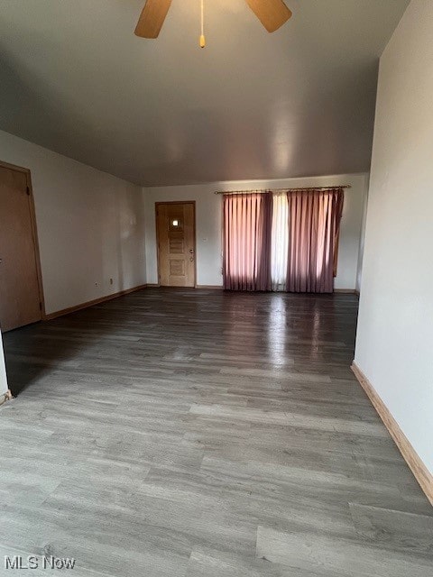 unfurnished living room featuring ceiling fan, baseboards, and wood finished floors