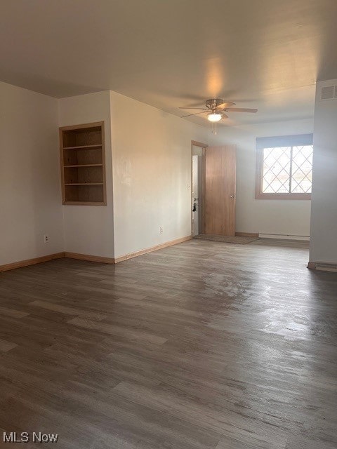 unfurnished room featuring visible vents, baseboards, and wood finished floors