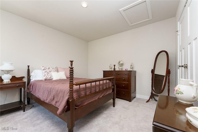 bedroom featuring attic access, light carpet, and baseboards