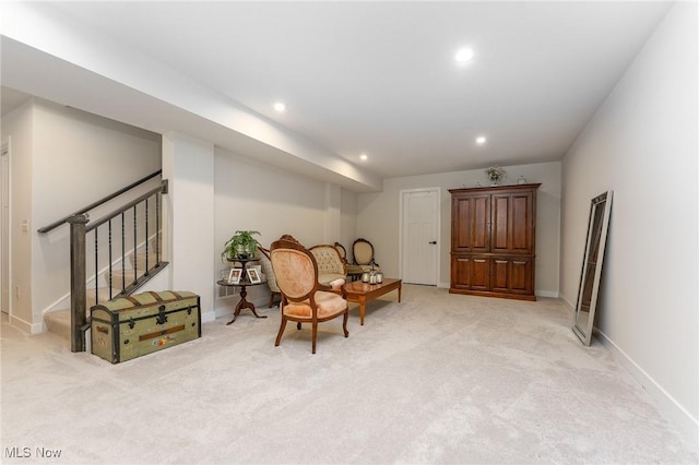 living area with recessed lighting, stairway, baseboards, and light colored carpet