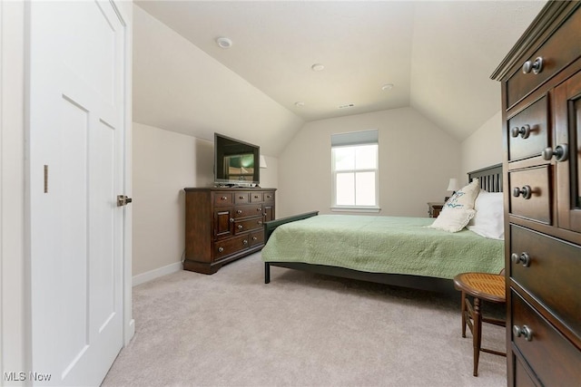 bedroom featuring light carpet, lofted ceiling, and baseboards