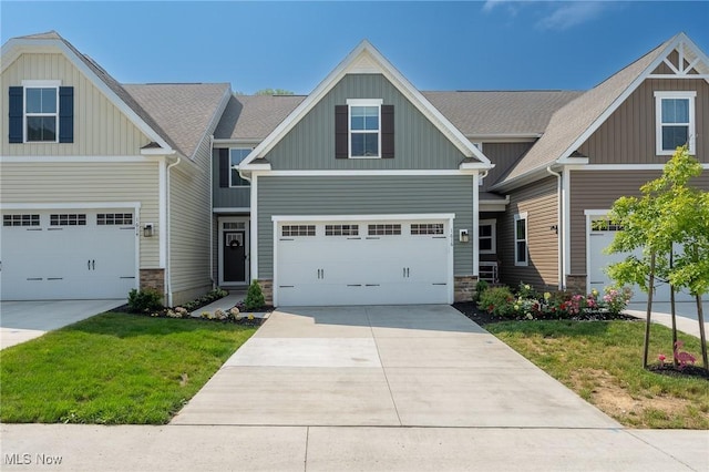 craftsman inspired home with a garage, concrete driveway, stone siding, board and batten siding, and a front yard