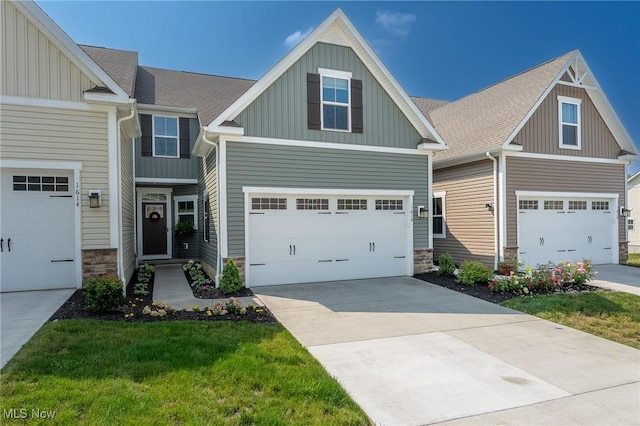 craftsman-style house featuring stone siding, a shingled roof, board and batten siding, and concrete driveway