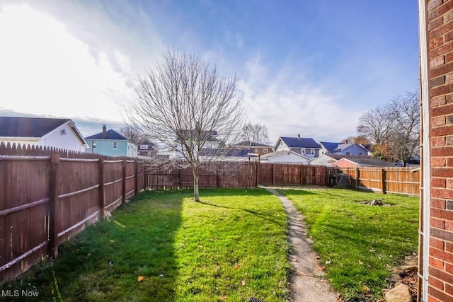 view of yard with a fenced backyard and a residential view