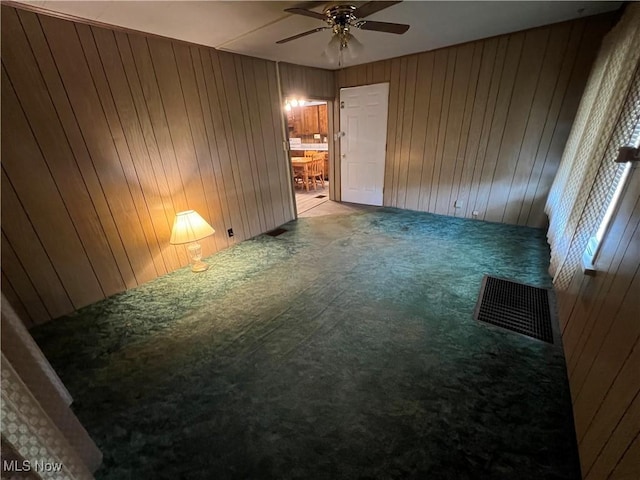 spare room featuring carpet floors and wood walls