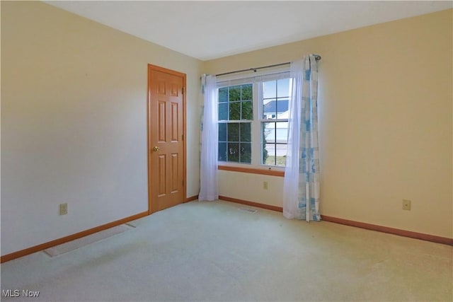 carpeted empty room featuring visible vents and baseboards