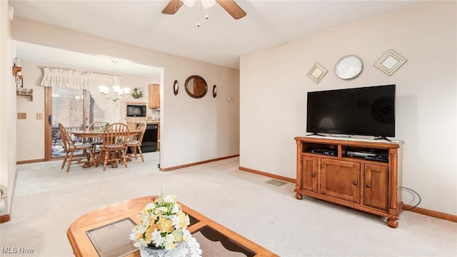 living room with carpet, baseboards, and ceiling fan with notable chandelier