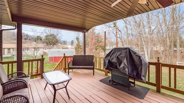 wooden deck featuring a yard and an outbuilding