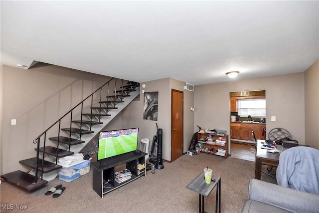 carpeted living room with visible vents, a sink, and stairway