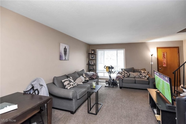 living room featuring carpet flooring and stairs