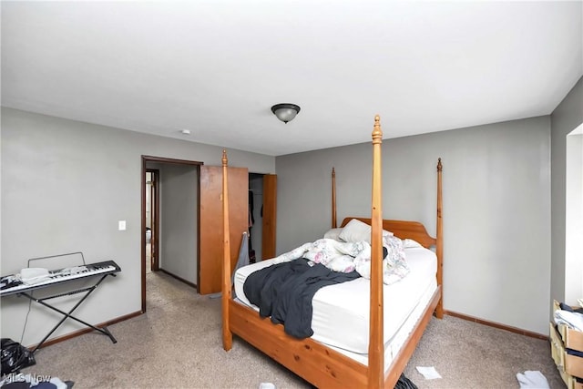 bedroom with light colored carpet and baseboards