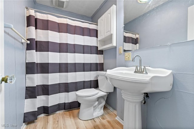 full bathroom featuring wood finished floors, toilet, and a shower with curtain