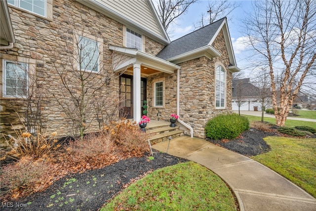 doorway to property featuring roof with shingles