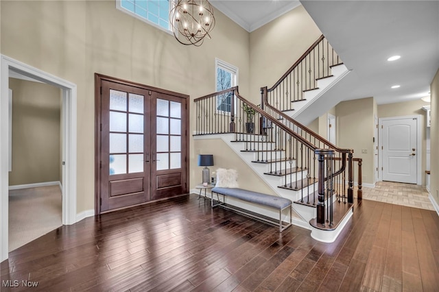 foyer featuring stairs, baseboards, wood finished floors, and french doors