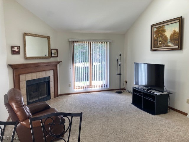 703 Tournament Trl, Cortland, OH 44410 - living area featuring a tiled fireplace, baseboards, vaulted ceiling, and carpet flooring