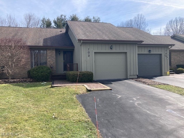703 Tournament Trl, Cortland, OH 44410 - ranch-style home with a garage, a shingled roof, aphalt driveway, a front lawn, and board and batten siding