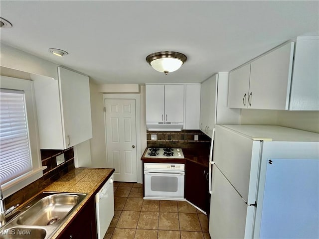 kitchen featuring white appliances, a sink, white cabinetry, and under cabinet range hood