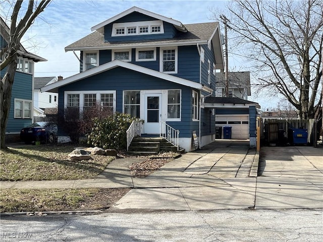 american foursquare style home with entry steps, a garage, fence, and concrete driveway