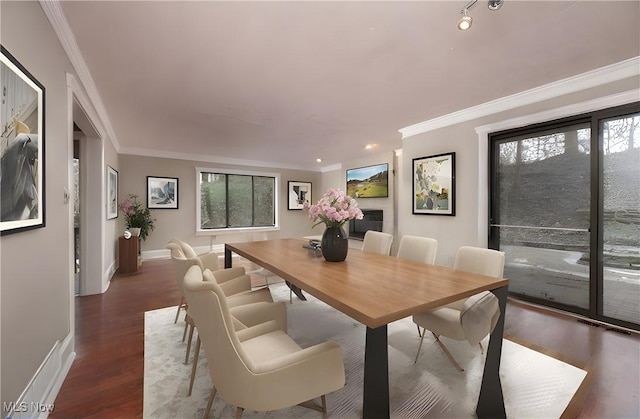 dining room featuring baseboards, ornamental molding, and wood finished floors