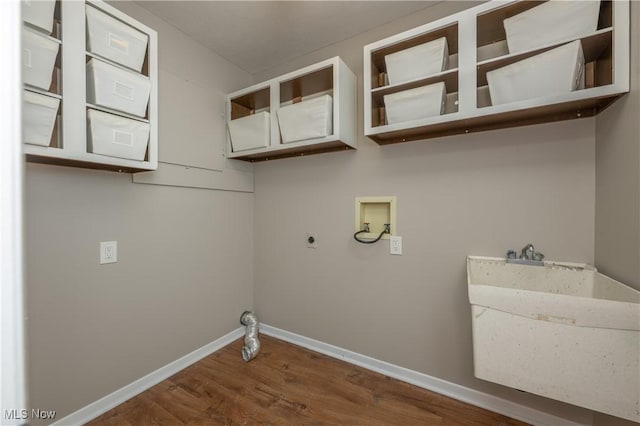 clothes washing area featuring laundry area, baseboards, wood finished floors, hookup for an electric dryer, and washer hookup