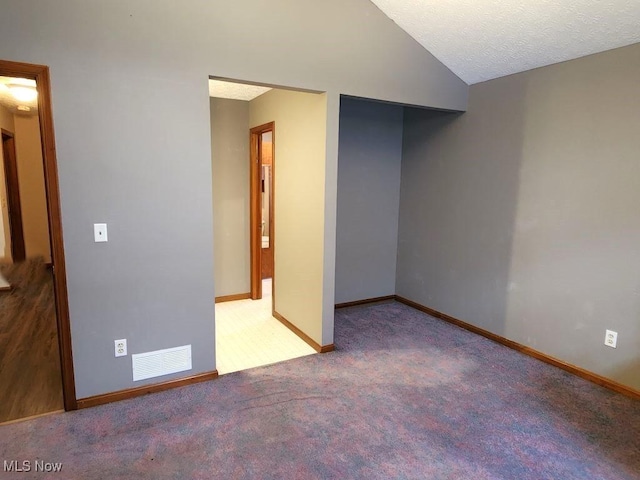 basement featuring carpet floors, baseboards, visible vents, and a textured ceiling