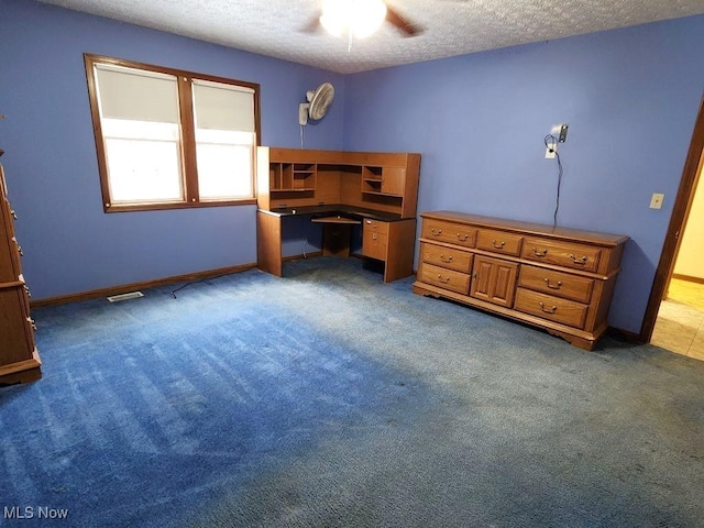 carpeted bedroom with baseboards, visible vents, ceiling fan, and a textured ceiling